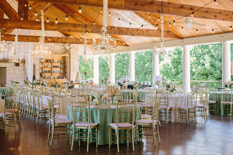 Wedding reception at White Oaks Ranch in Dallas with cafe lights and chandeliers and chiavari chairs
